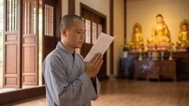 Người Phật tử thành tâm chắp tay đọc văn khấn sám hối tại chùa trước ban Tam Bảo thanh tịnh