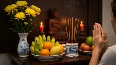 Người chắp tay thành kính trước bàn thờ gia tiên rực sáng ánh nến và hương khói sau khi hoàn tất việc bao sái