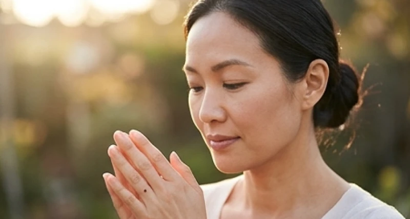 Người phụ nữ mỉm cười nhẹ nhàng khi xem nốt ruồi ở ngón tay dưới ánh nắng