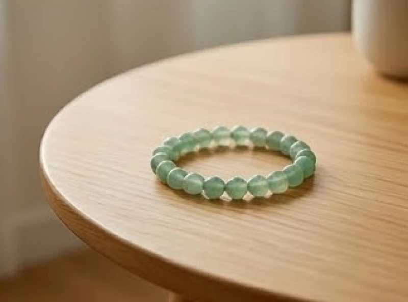 Một chiếc vòng tay đá mã não xanh lá cây được đặt trang trọng trên bàn gỗ giúp hóa giải năng lượng xấu