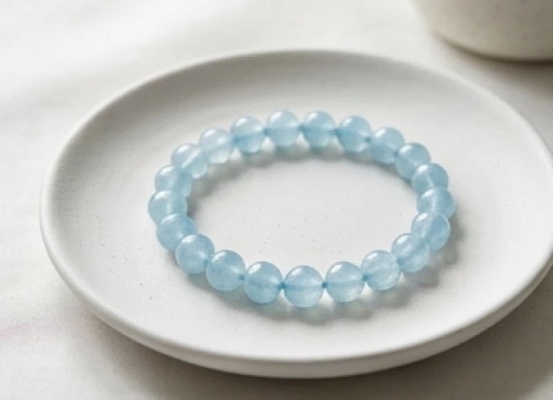 Vòng tay đính những viên đá Aquamarine màu xanh lam trong vắt đặt trên đĩa sứ
