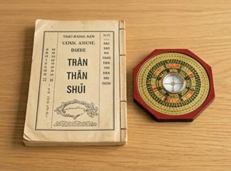 Lịch vạn niên và la bàn phong thủy đặt trên bàn gỗ để chọn ngày lành tháng tốt tiến hành cải tạo bếp