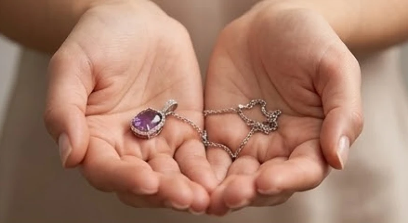 Đứt dây chuyền là điềm gì: Tra cứu khung giờ và cách hóa giải 2 Mặt dây chuyền đá quý và sợi dây bị đứt gãy nằm gọn trong lòng bàn tay thể hiện sự nâng niu