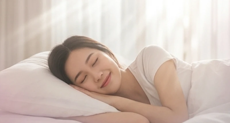 Cô gái trẻ người châu Á đang ngủ say với nét mặt mỉm cười hạnh phúc trên chiếc gối trắng mềm mại